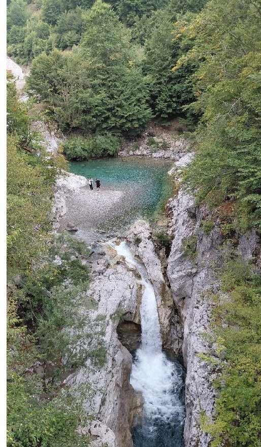 Waterfall and turquoise swimming pool in the Bashkim canyon near Vermosh